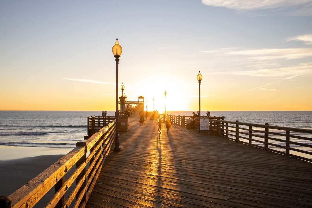 Dock en bois brun sur la mer pendant le coucher du soleil puzzle en ligne