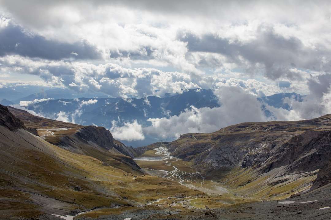 коричневі та зелені гори під білими хмарами та блакитним небом онлайн пазл