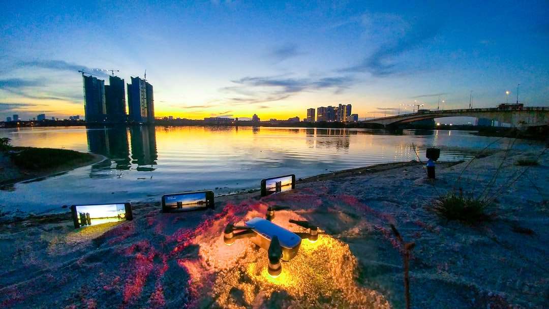 υδάτινο σώμα κοντά σε γέφυρα και κτίρια της πόλης κατά το ηλιοβασίλεμα παζλ online