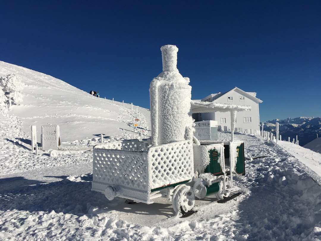casă acoperită de zăpadă albă și neagră sub cer albastru jigsaw puzzle online