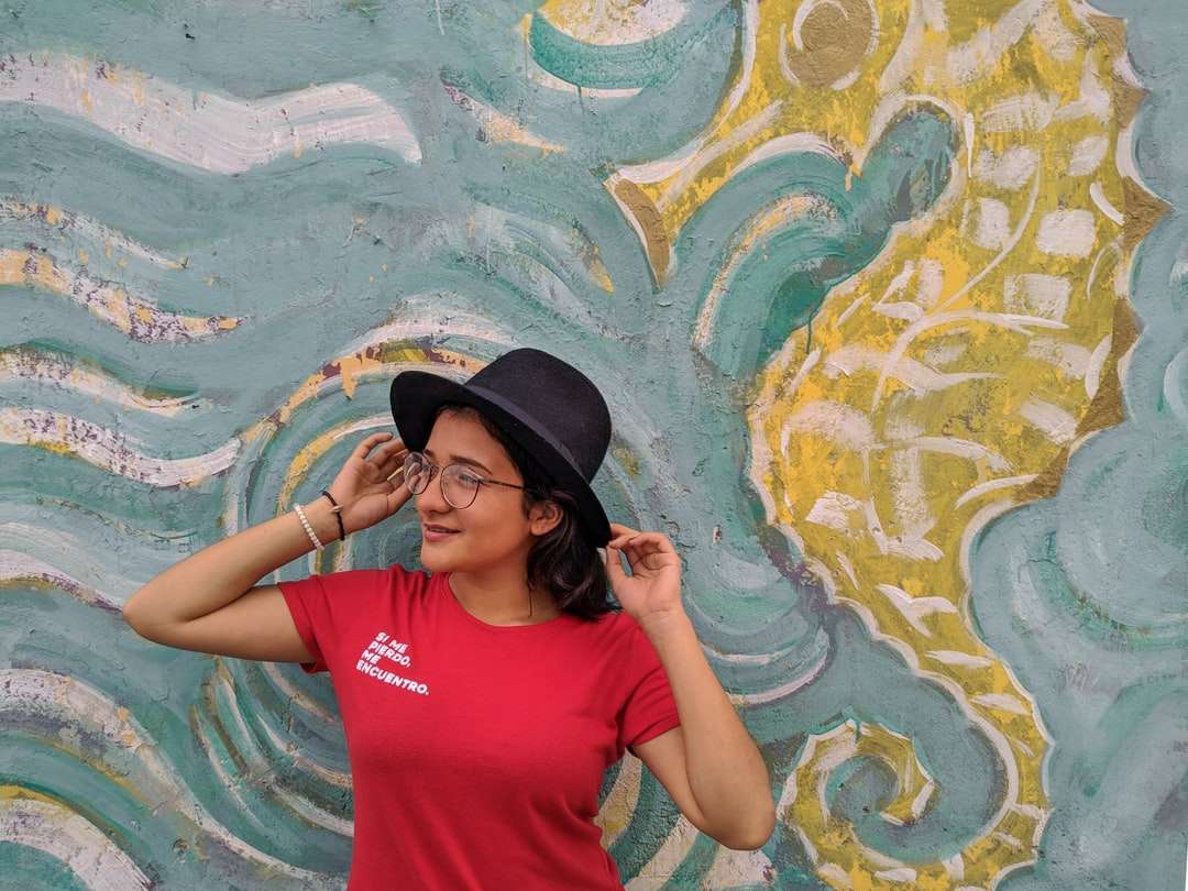 Frau im roten Rundhalsausschnitt-T-Shirt, das schwarzen Hut trägt Puzzlespiel online