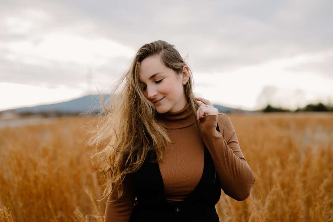 kvinna i svart linne som står på fältet för brunt gräs Pussel online