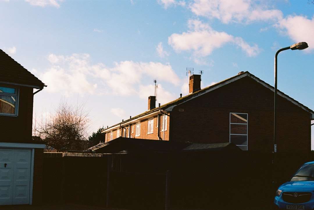 белый и коричневый деревянный дом возле голых деревьев под голубым небом онлайн-пазл