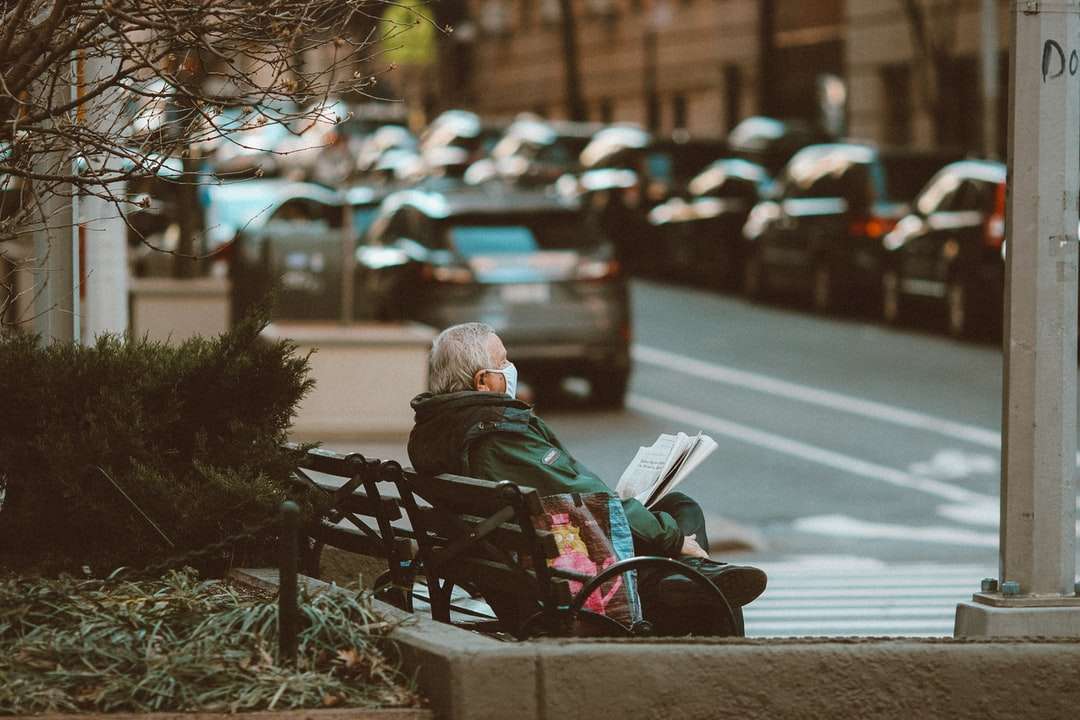 nő fekete kabátban ül a padon az utcán online puzzle