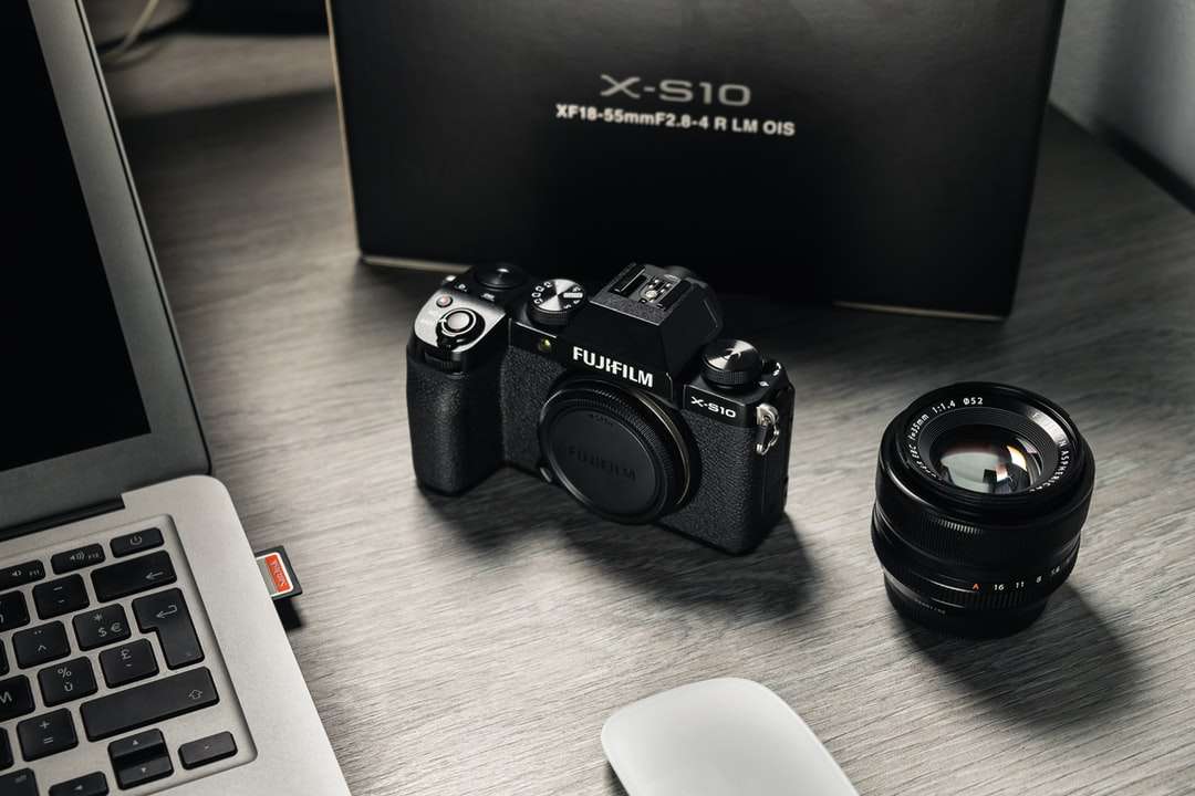 svart Nikon DSLR-kamera bredvid vitt datortangentbord Pussel online