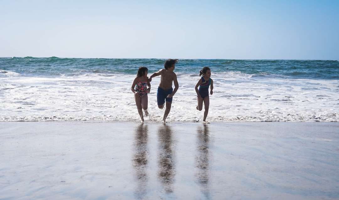 3 женщины в черном бикини стоят на пляже днем онлайн-пазл