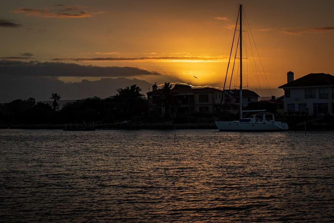 білий човен на морі під час заходу сонця пазл онлайн