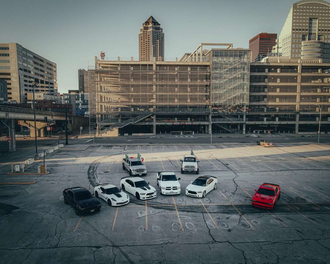 Automóviles estacionados en el estacionamiento cerca del edificio de hormigón marrón rompecabezas en línea