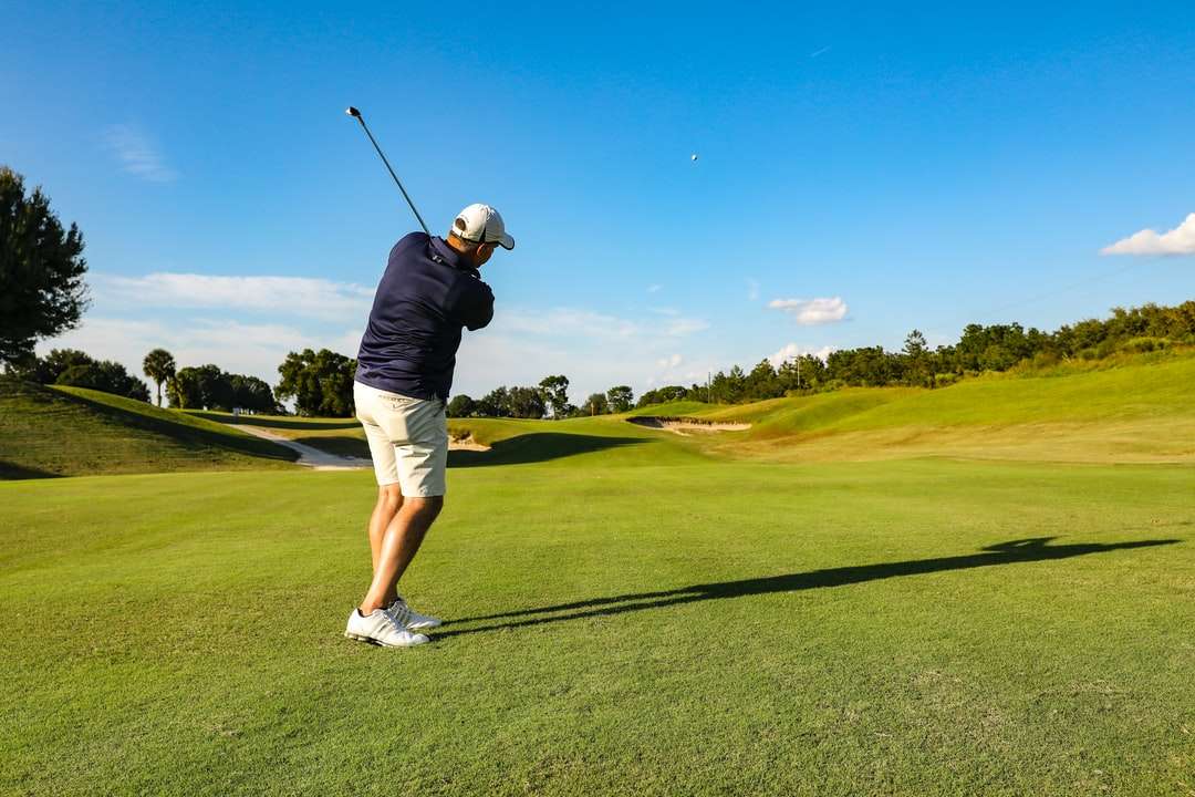 Mann im schwarzen T-Shirt und in den weißen Shorts, die Golf spielen Online-Puzzle