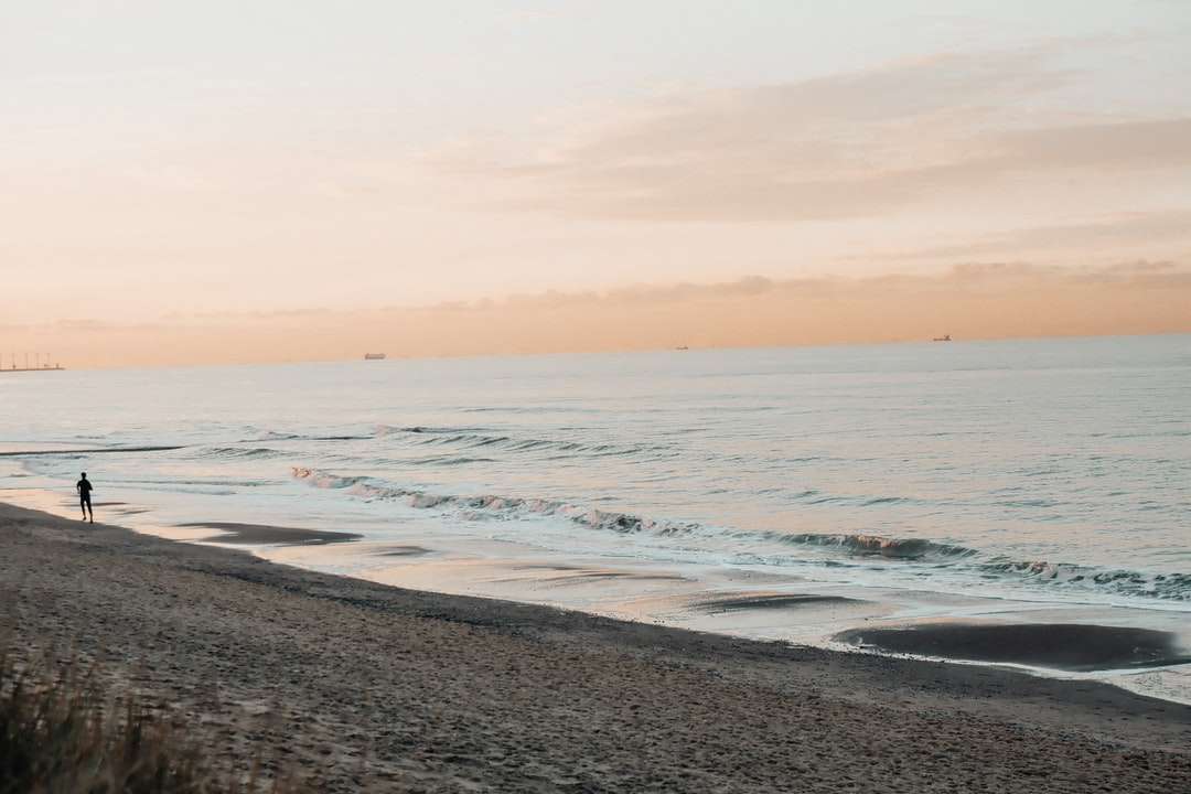 морские волны разбиваются о берег во время заката пазл онлайн
