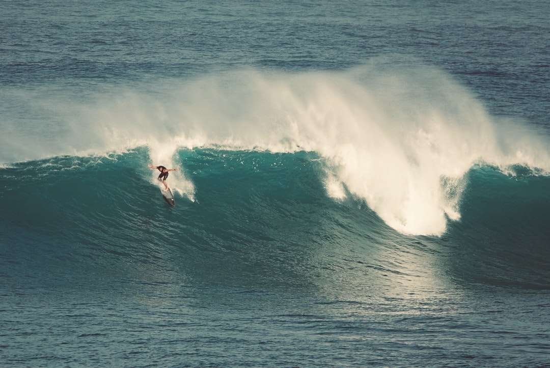 човек, който сърфира на морски вълни през деня онлайн пъзел