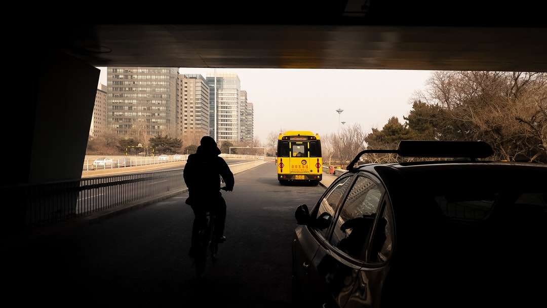 黄色いスクールバスの横に立っている黒いジャケットの男 オンラインパズル