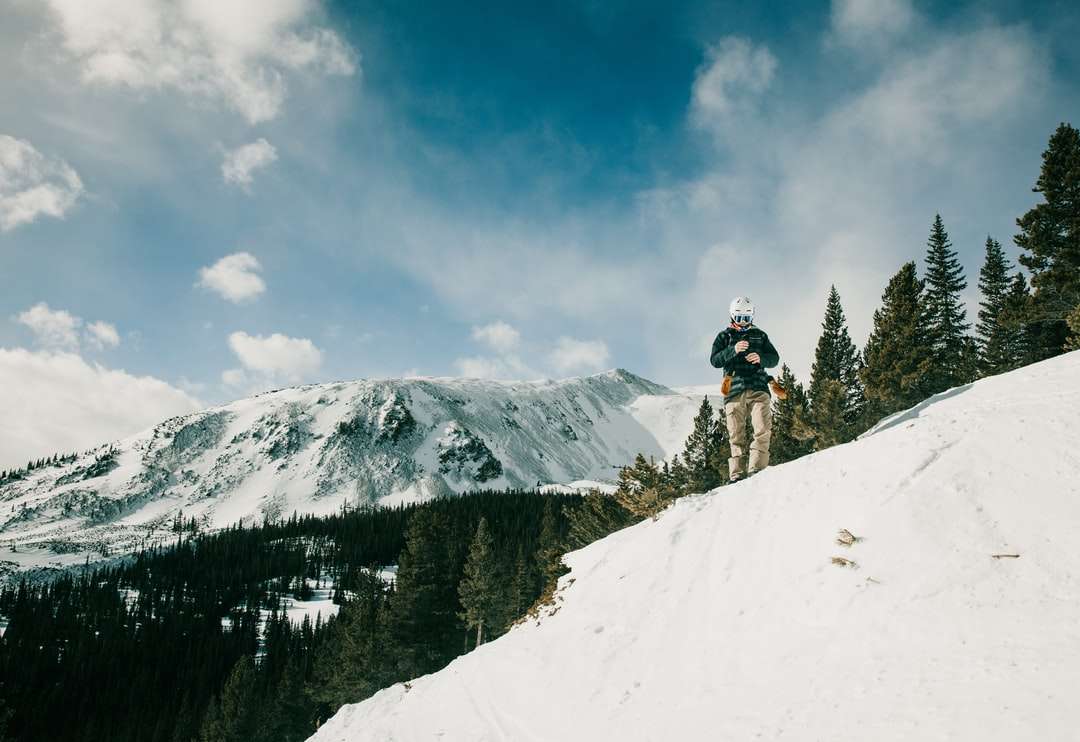 pessoa de jaqueta preta e calça preta andando de esqui na neve quebra-cabeças online
