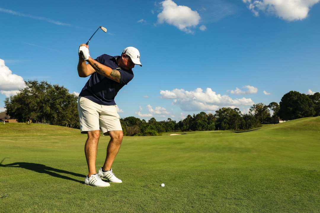 homem de camisa preta e calção branco jogando golfe puzzle online