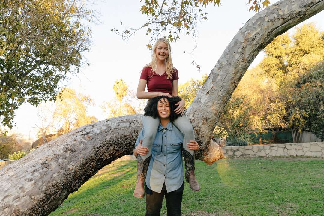 žena v šedých šatech bez rukávů, stojící vedle hnědého stromu skládačky online