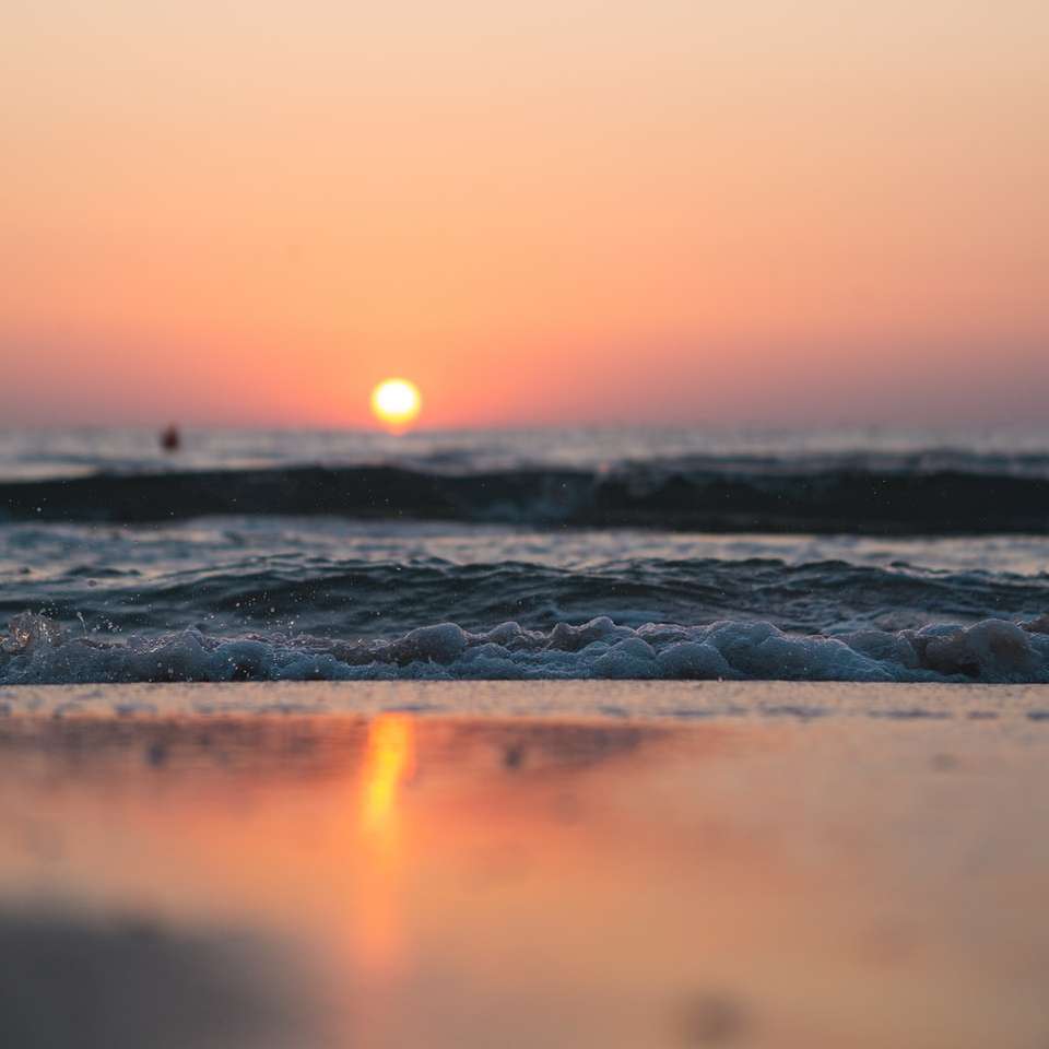 морські хвилі розбиваються на берег під час заходу сонця онлайн пазл