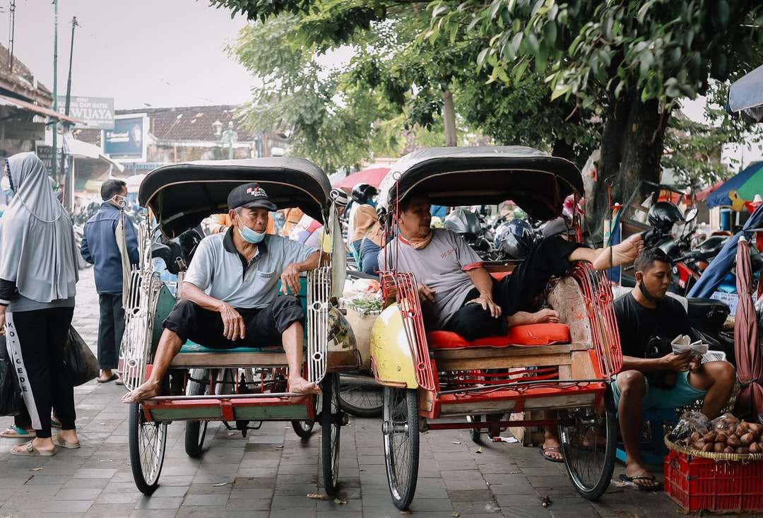 oameni care călătoresc pe ricșă roșie și neagră în timpul zilei puzzle online