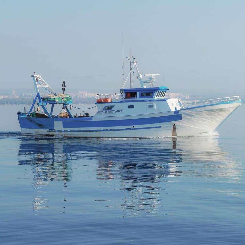 Рыбацкая лодка возвращается в порт Таранто Италия онлайн-пазл