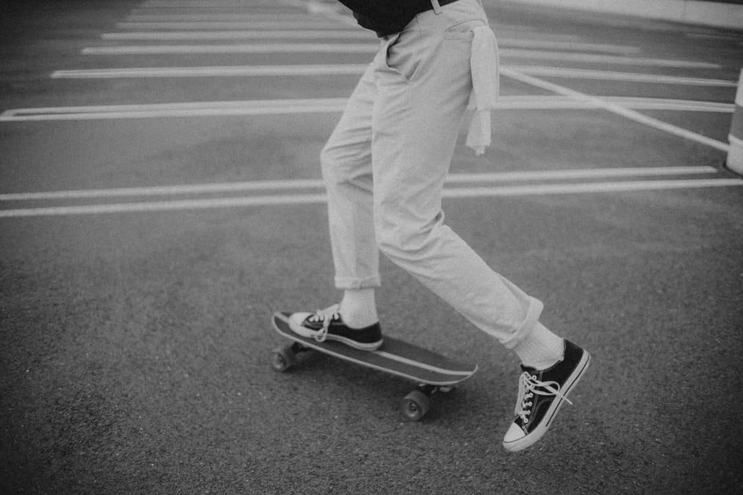 άντρας με μαύρο φούτερ και άσπρο παντελόνι στέκεται στο skateboard παζλ online
