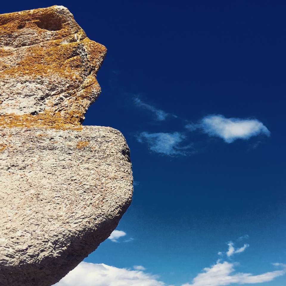 šedý skalní útvar pod modrou oblohou během dne online puzzle