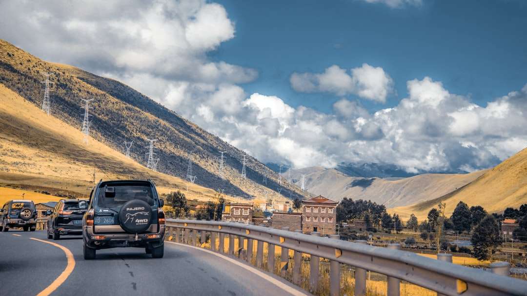 SUV noir sur route près de la montagne sous le ciel bleu puzzle en ligne