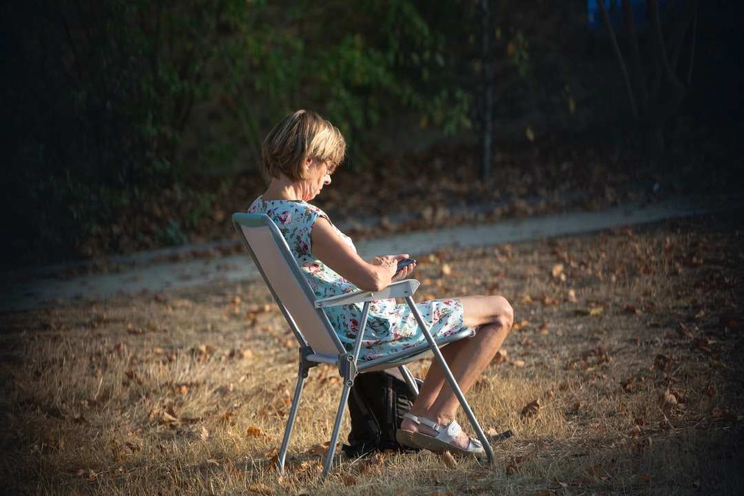niño en camiseta azul sentado en una silla plegable rompecabezas en línea