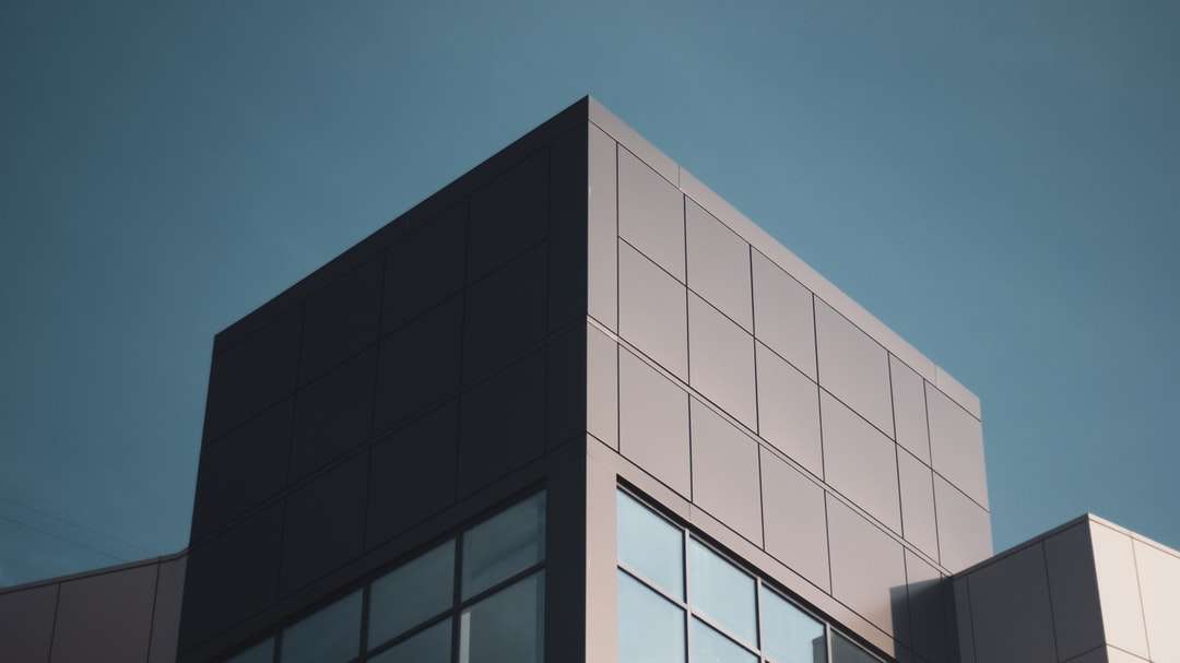 бяла и черна бетонна сграда под синьо небе онлайн пъзел
