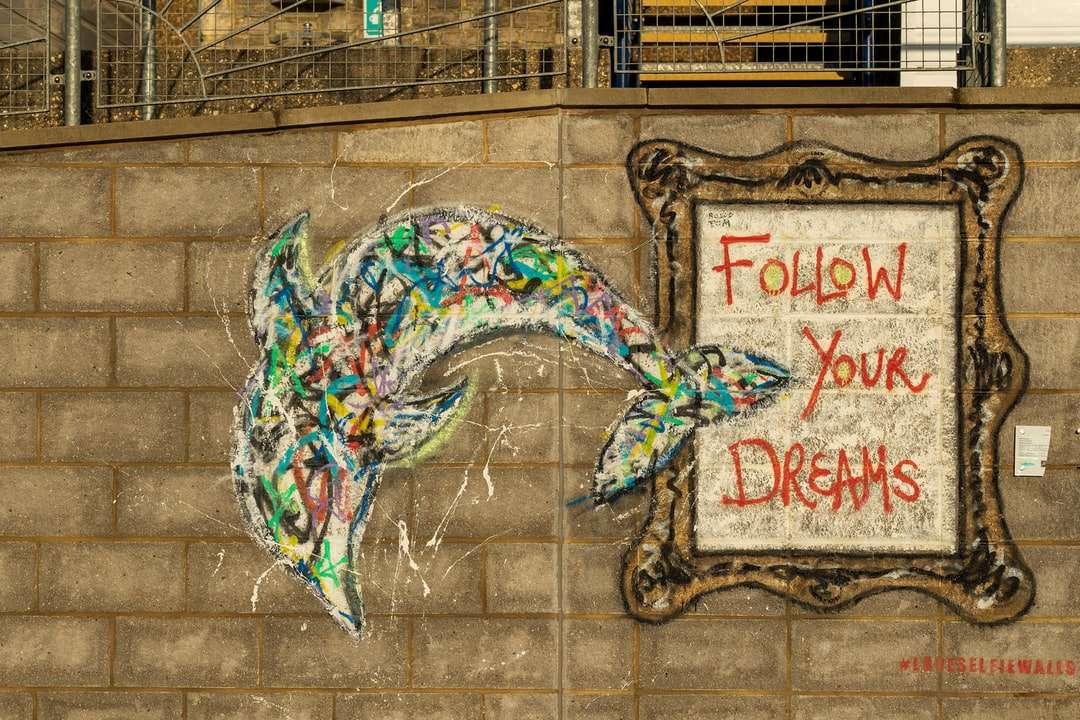 blågrön och vit blommig graffiti på brun tegelvägg Pussel online