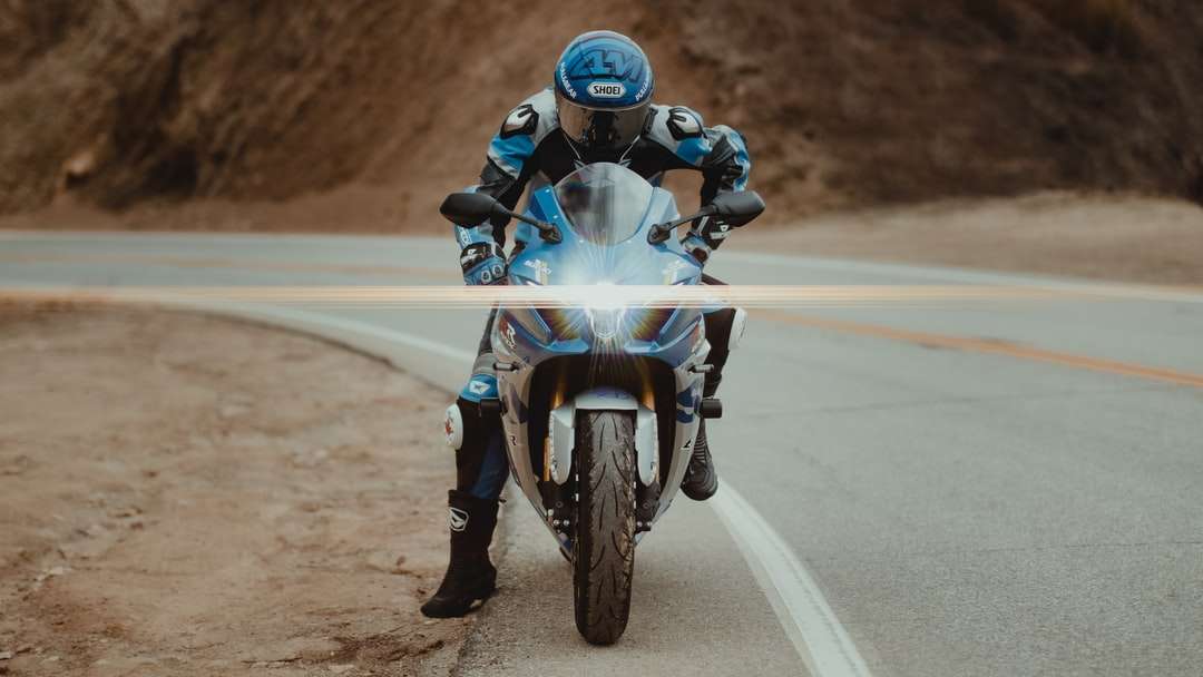 мъж в синьо-бял мотоциклет костюм каране на мотоциклет онлайн пъзел