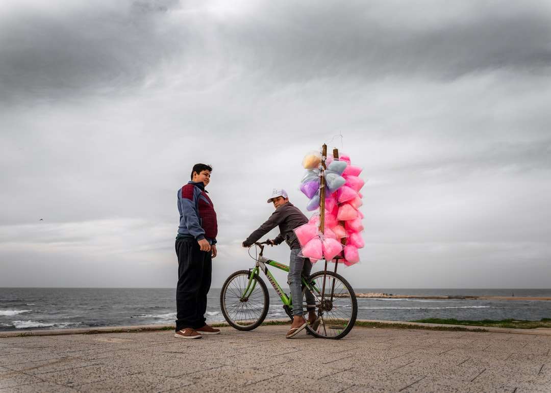 Hombre y mujer montando bicicleta en la playa durante el día rompecabezas en línea