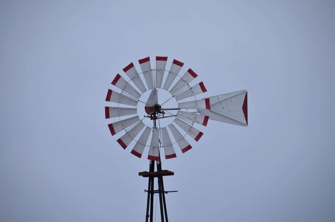 weiße und rote Windmühle unter weißem Himmel während des Tages Puzzlespiel online