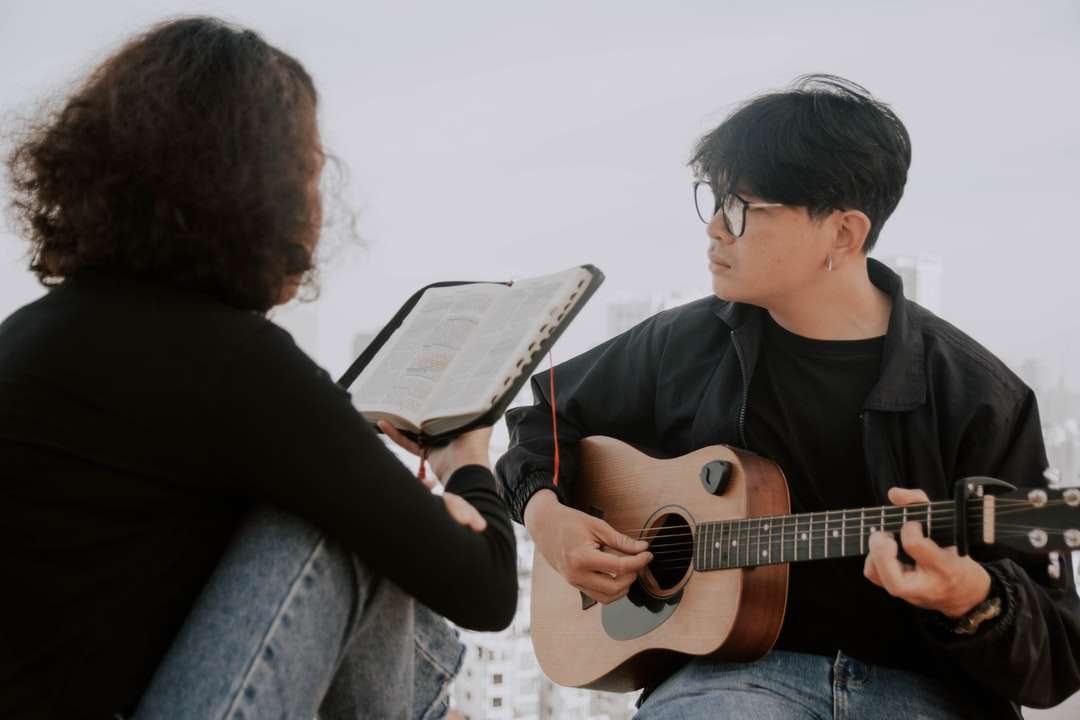 мужчина в черной рубашке с круглым вырезом играет на акустической гитаре онлайн-пазл