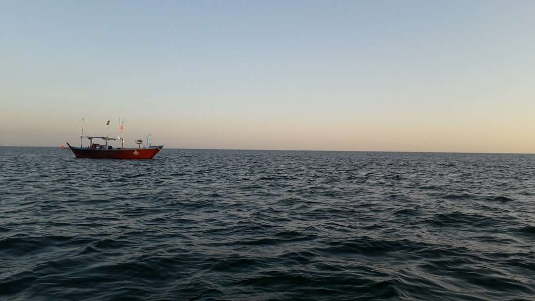 röd och vit båt på havet under dagtid pussel på nätet