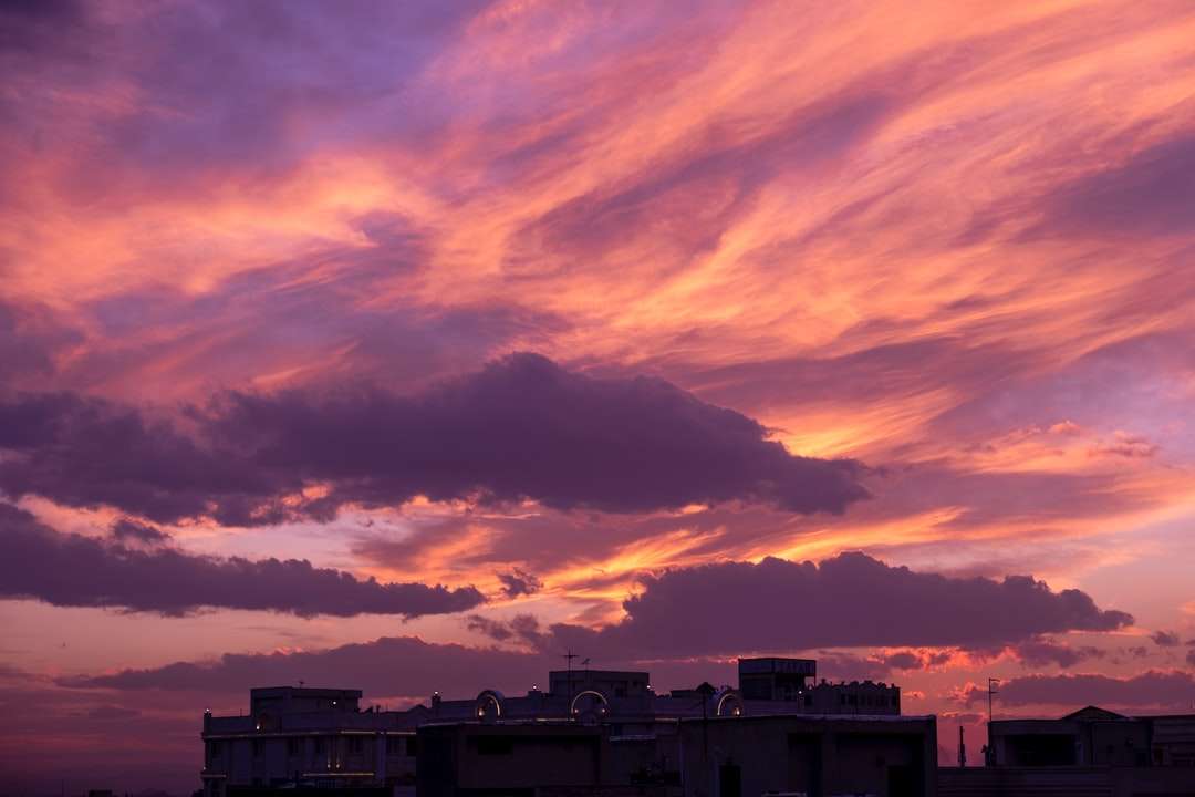 weißes Betongebäude unter bewölktem Himmel während des Sonnenuntergangs Online-Puzzle