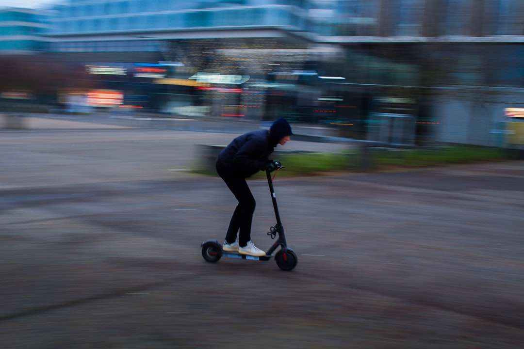 мъж в черно яке, каране на черен скутер на пътя онлайн пъзел