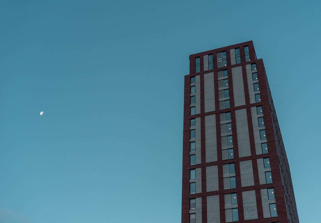 κόκκινο και μαύρο κτίριο κάτω από το γαλάζιο του ουρανού παζλ online