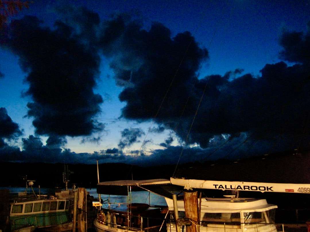 witte en bruine houten boot op dok onder blauwe hemel online puzzel