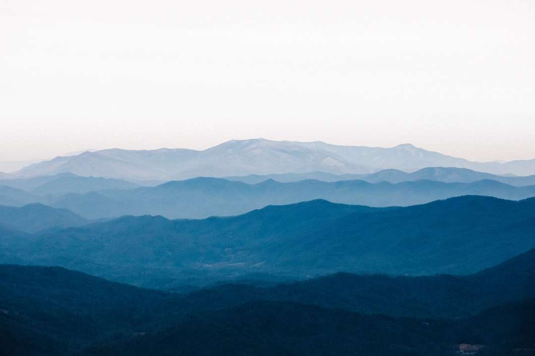 καταπράσινα βουνά κάτω από τον λευκό ουρανό κατά τη διάρκεια της ημέρας παζλ online