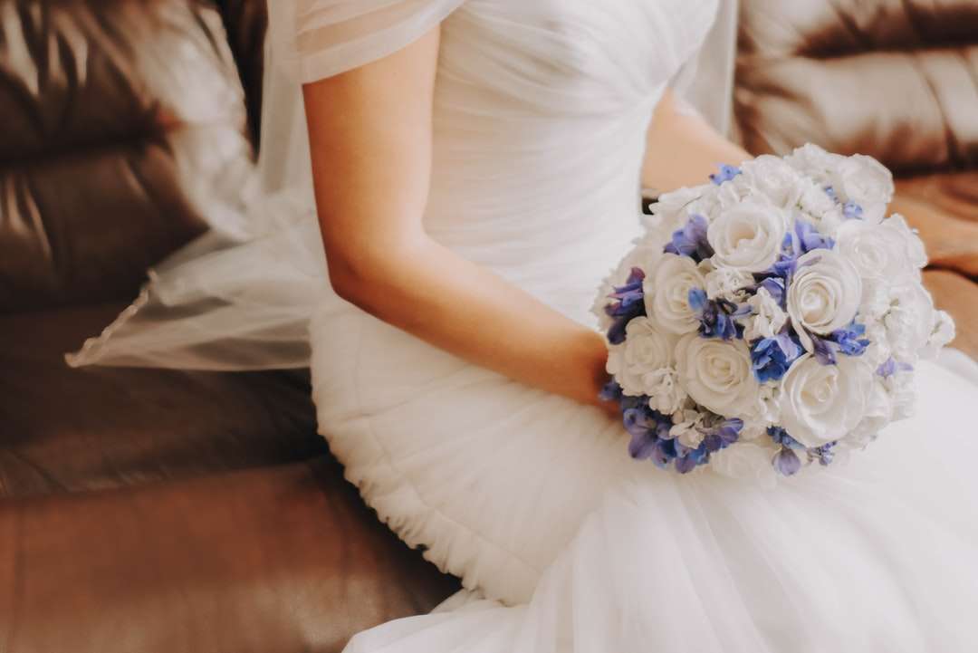 Frau im weißen Kleid, das blauen Blumenstrauß hält Online-Puzzle