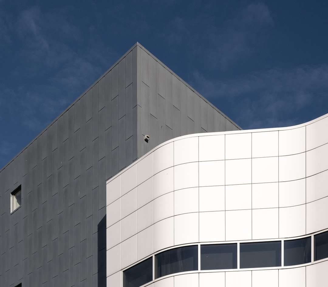 белое бетонное здание под голубым небом в дневное время пазл онлайн