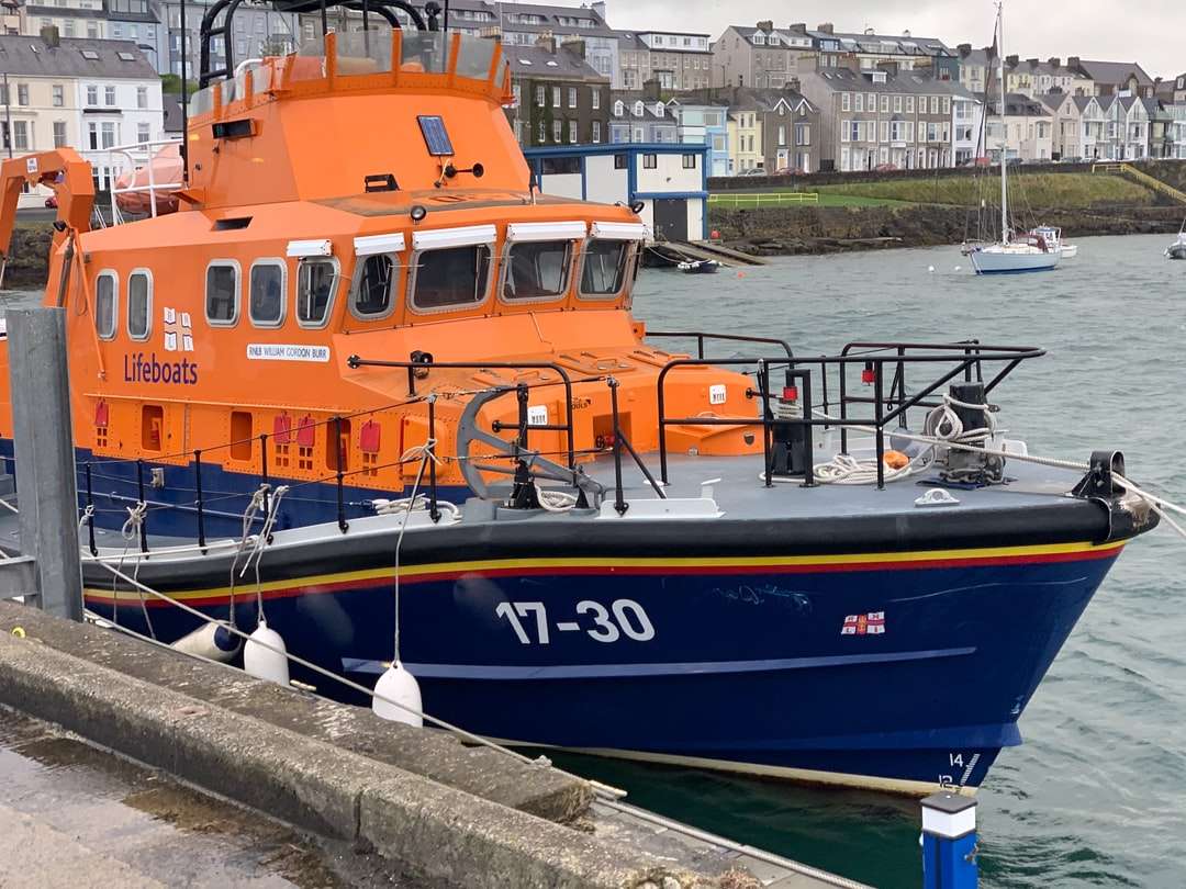 blauwe en oranje boot op dok overdag legpuzzel online