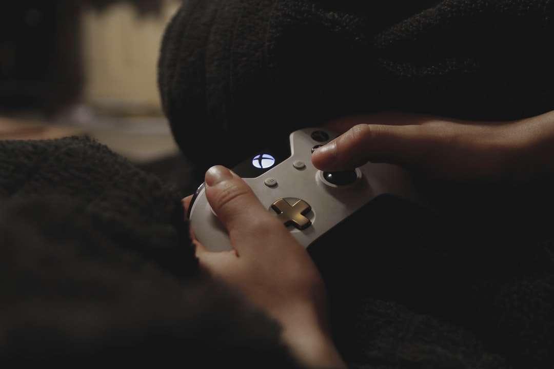 osoba, která drží bílý herní ovladač pro Xbox skládačky online