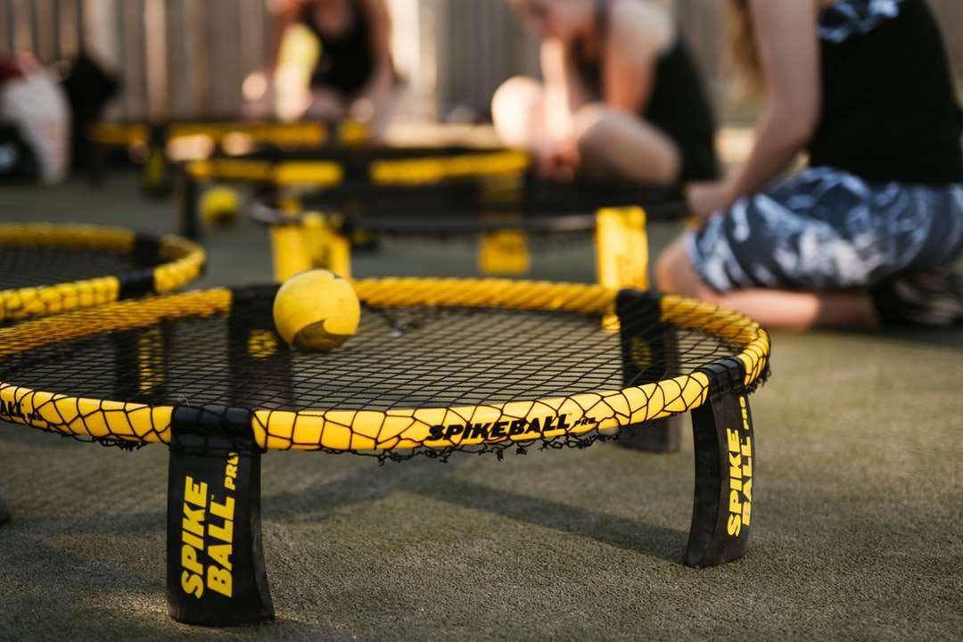 gul tennisboll på svart och gul studsmatta Pussel online