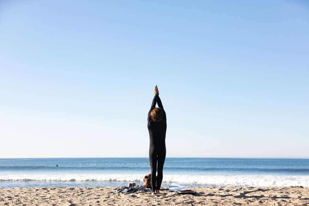 жінка в чорній сукні, стоячи на пляжі в денний час онлайн пазл