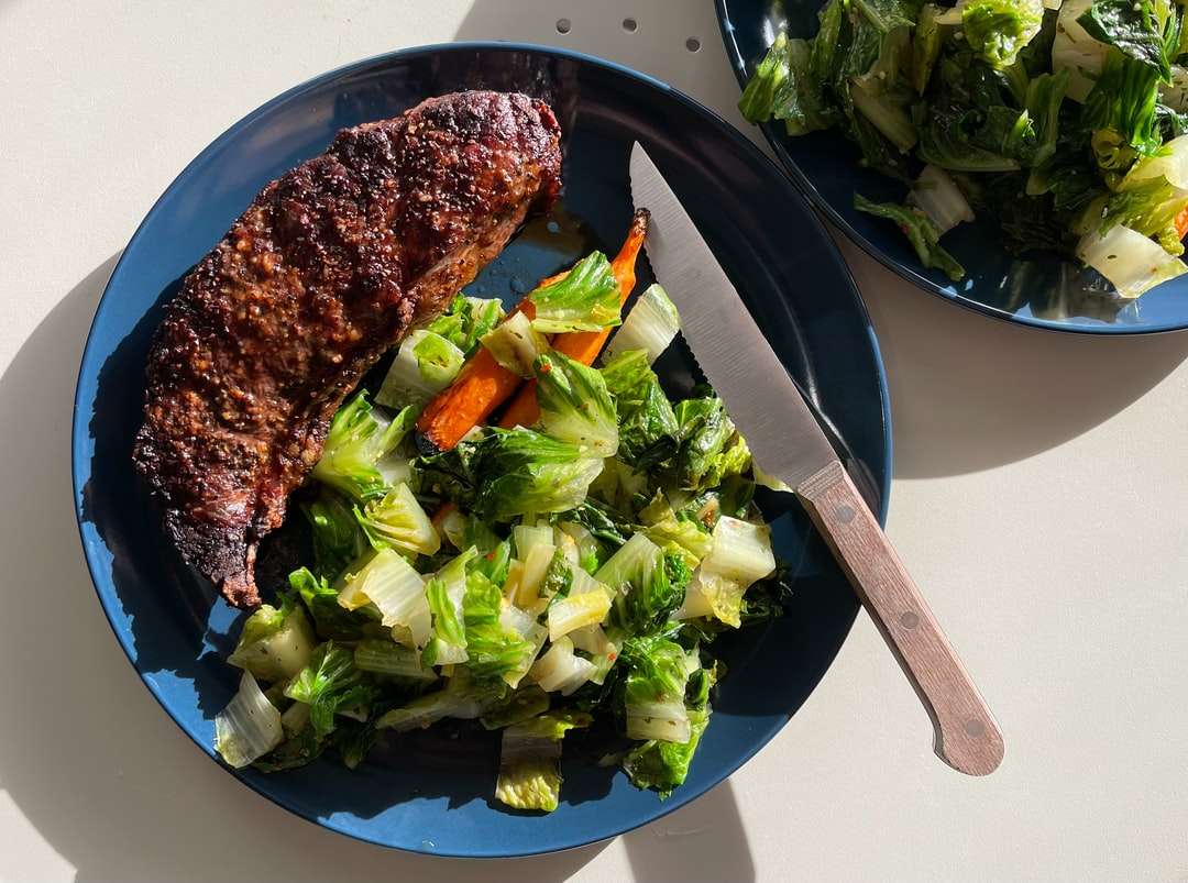 приготовленное мясо с овощами на черной тарелке пазл онлайн