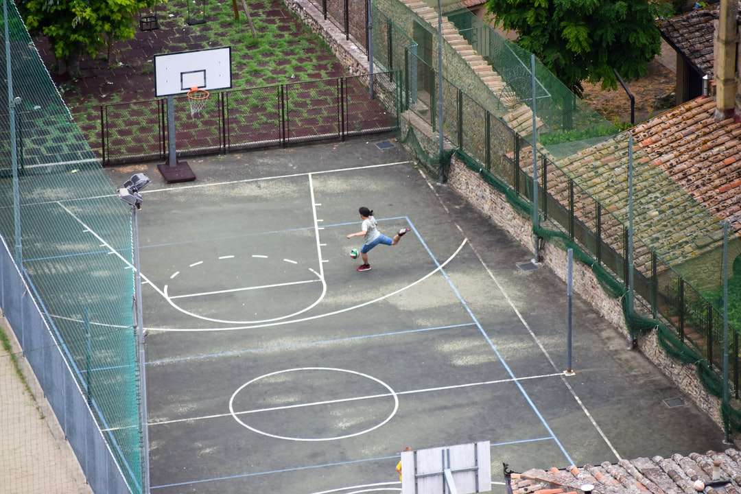 женщина в белой рубашке сидит на баскетбольной площадке онлайн-пазл