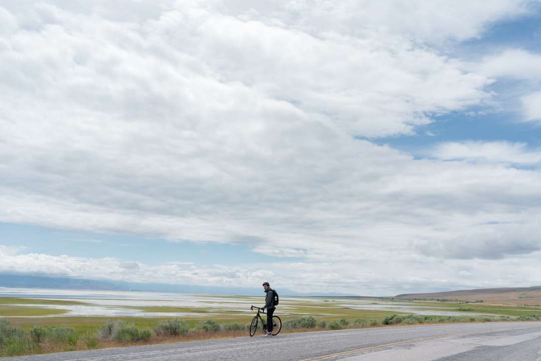 мъж в черна риза и черен панталон, каращ велосипед онлайн пъзел