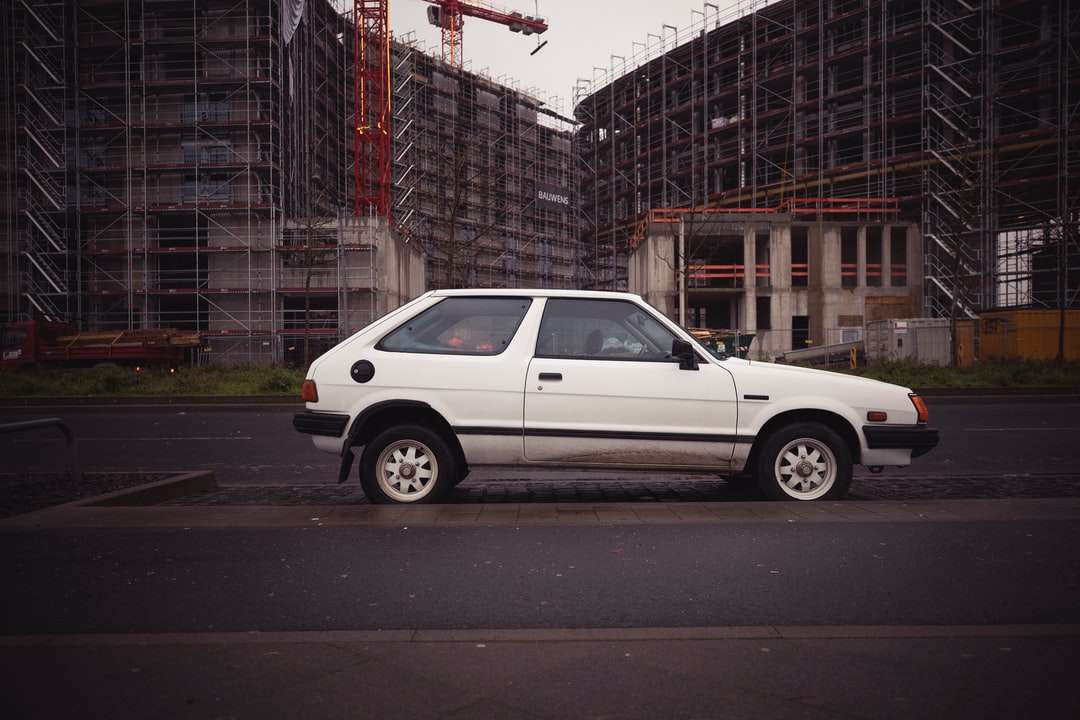 bílé SUV zaparkované na chodníku poblíž budovy během dne online puzzle