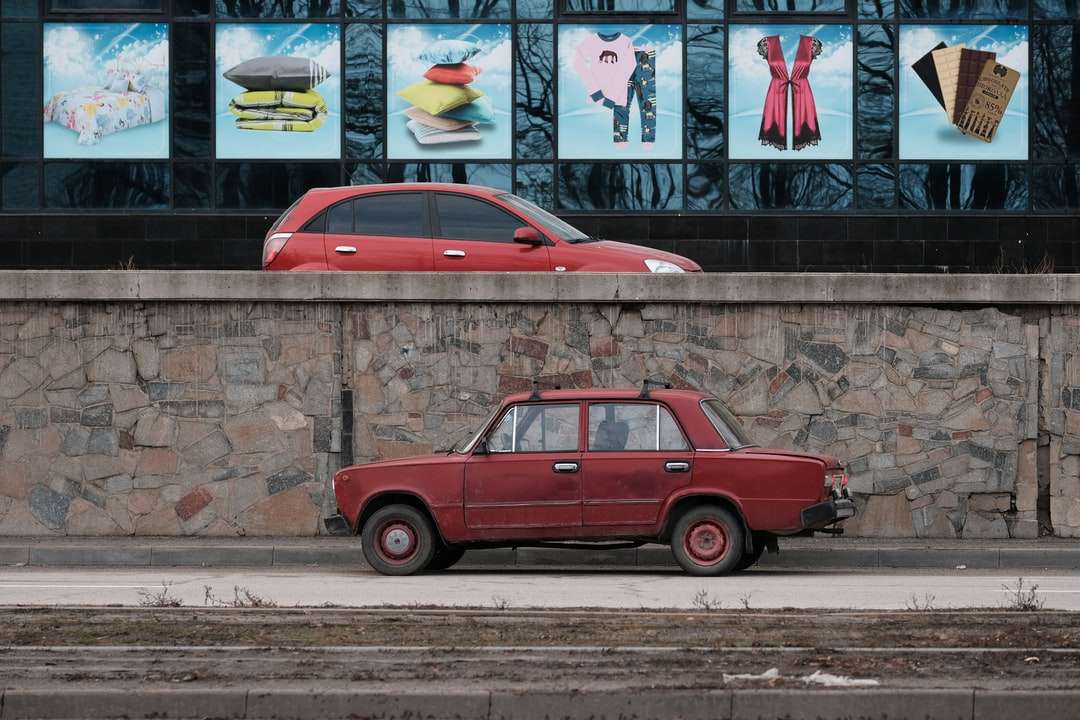 Berline rouge garée à côté du mur avec des graffitis puzzle en ligne