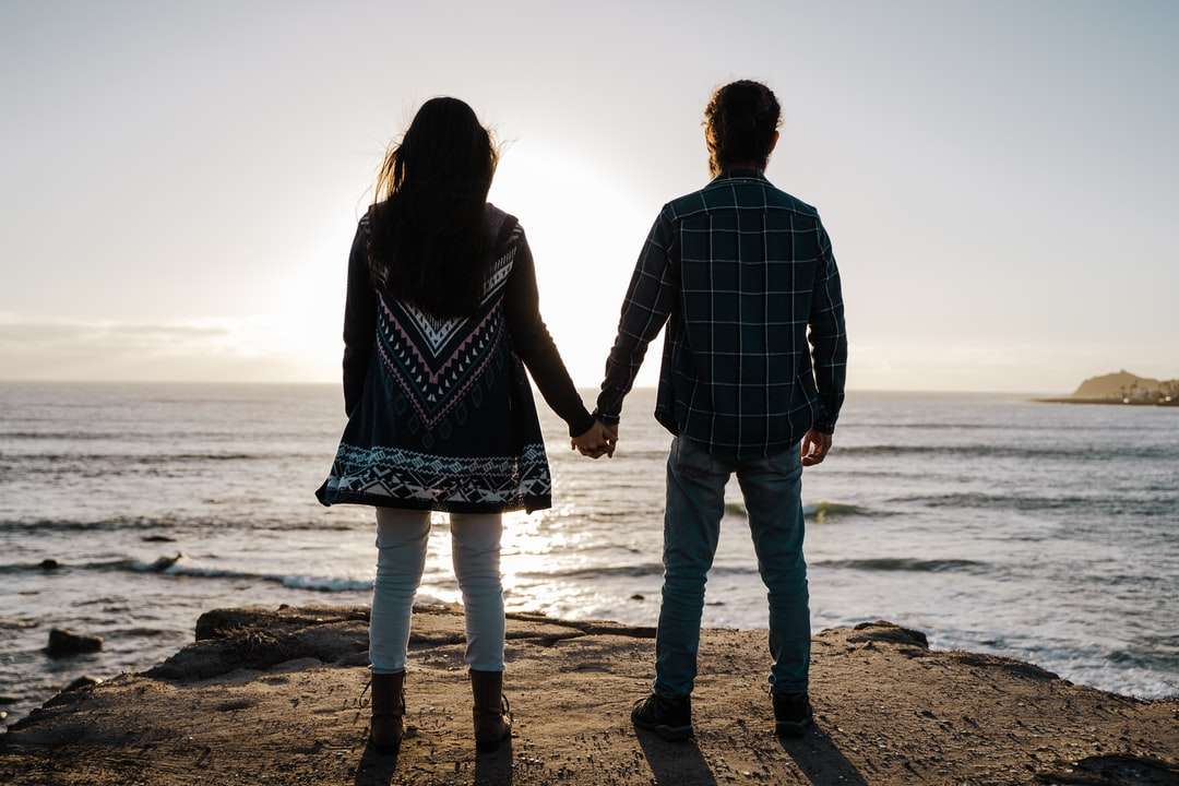 мъж и жена, хванати за ръце, докато се разхождате на плажа онлайн пъзел